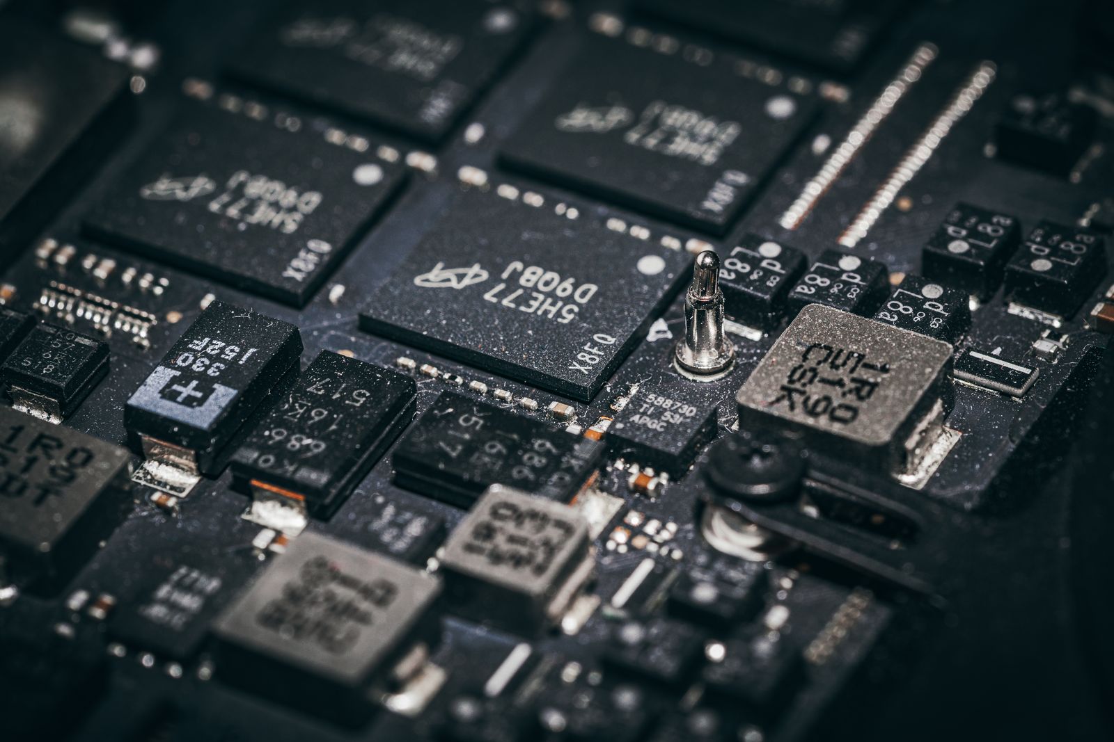 Ảnh macro cận cảnh các chip nhớ và linh kiện trên một bo mạch tối màu